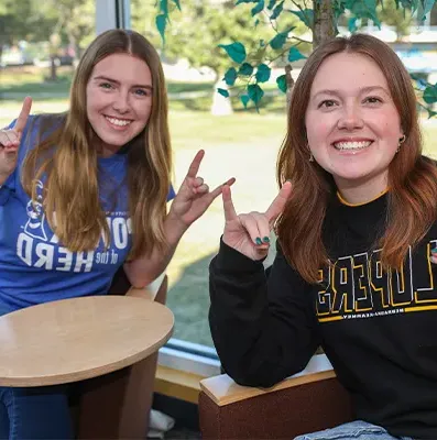 two students sit together and pose for a photo